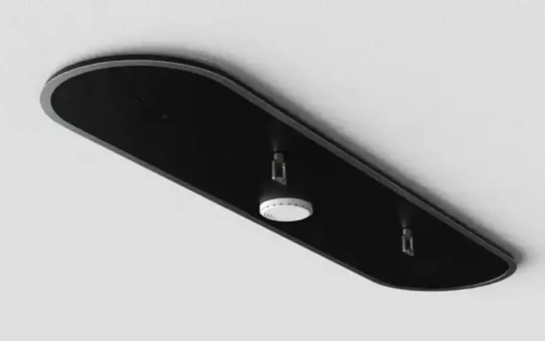 Ceiling-mounted modern fire suppression system with dual nozzles and a central detector on a sleek black panel.